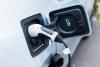 An electric car has its charger plugged into the socket.