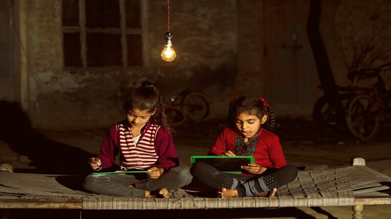         Kids writing on a slate, using a light bulb
      